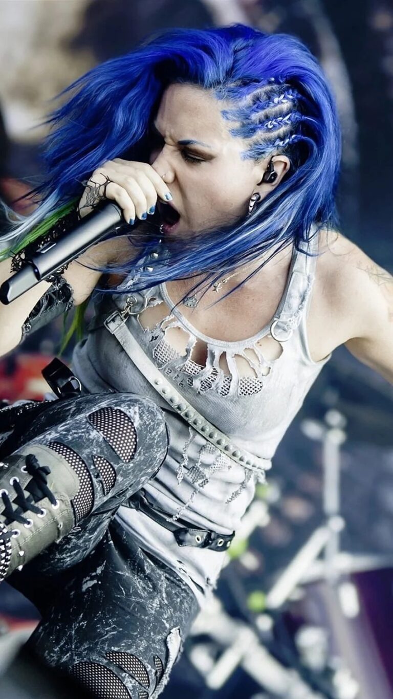 A photo of Alissa White-Gluz screaming into a microphone