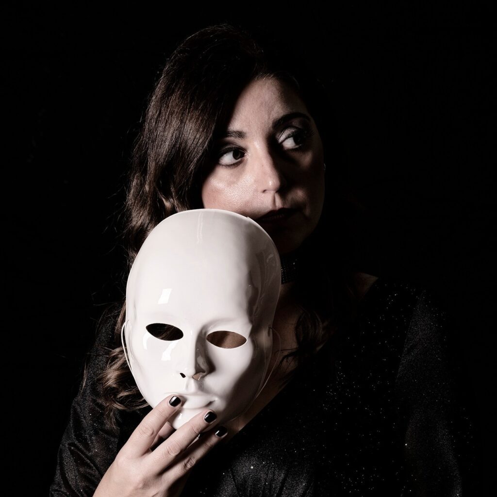 Eleonora Travaglino holding white mask next to her face